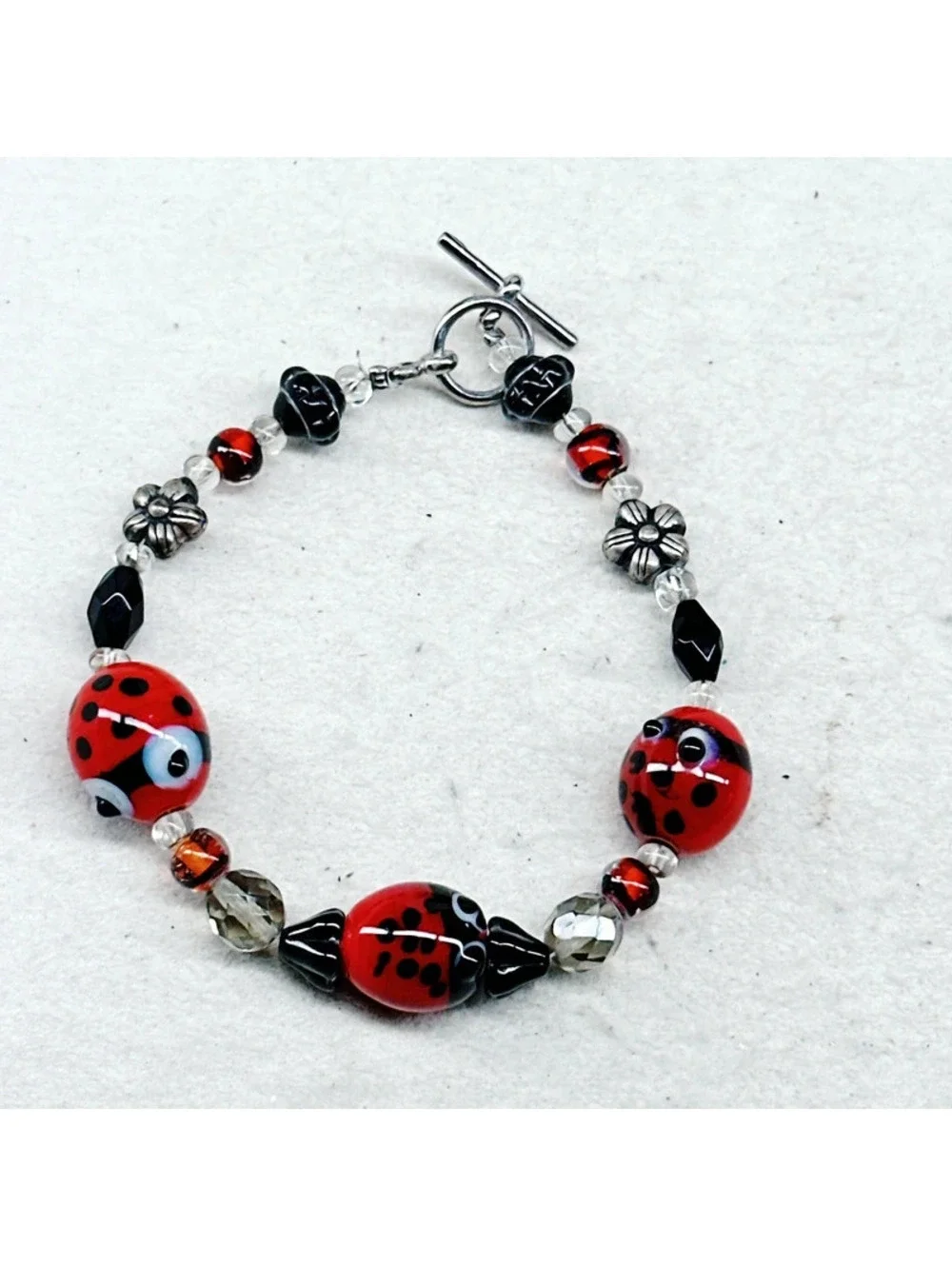 3011u. Silly Ladybug Glass Bracelet Silvertone